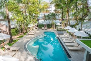 an image of a pool with lounge chairs and umbrellas at Deevana Krabi Resort in Ao Nang Beach