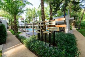 a street sign in front of a pool with palm trees at Deevana Krabi Resort in Ao Nang Beach