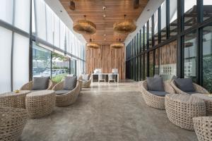 a lobby with wicker chairs and tables in a building at Deevana Krabi Resort in Ao Nang Beach