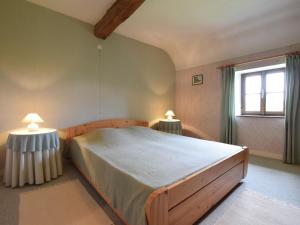 ヴェリスにあるAuthentic Cottage in Weris with Private Gardenのベッドルーム1室(大型ベッド1台、ランプ2つ付)