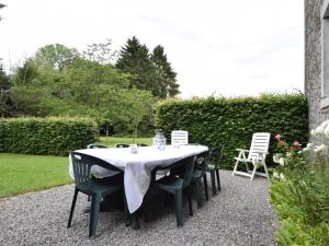 a table with chairs and a white table cloth on it at Authentic Cottage in Weris with Private Garden in Weris