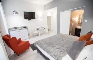 1 dormitorio con 1 cama y 1 silla roja en City Center Stúdió Apartmanok en Szeged