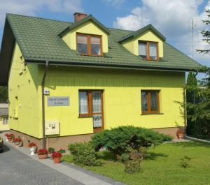 una casa amarilla con techo verde en Apartament Luna, en Zamość