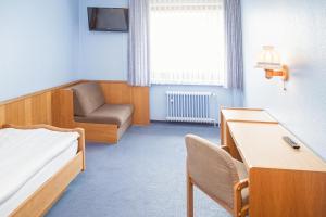 Habitación hospitalaria con cama y silla en Hotel Hannover Airport by Premiere Classe en Hannover