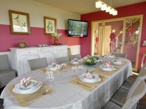 ein Esszimmer mit einem langen Tisch mit Tellern und Gläsern in der Unterkunft Wonderful Holiday Home in Ovifat with Sauna in Ovifat