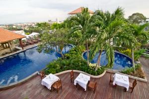 a patio area with tables, chairs and umbrellas at Sunshine Vista Hotel - SHA Plus in Pattaya