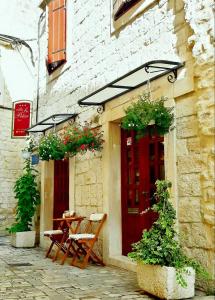 een tafel en stoelen voor een gebouw met een rode deur bij Villa Sv. Petar in Trogir