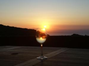 a glass of wine with the sunset in the background at Charming Holiday Home in Kritinia with Garden in Kritinía