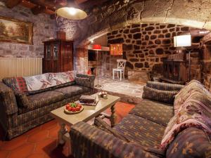 una sala de estar con sofás y una chimenea de piedra. en Charming Farmhouse in Cros de G orand with Swimming Pool en Cros-de-Géorand