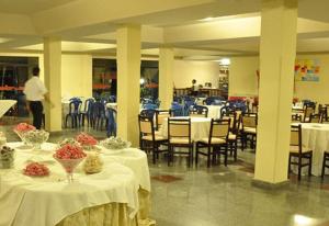 uma sala de jantar com mesas e cadeiras com roupa de mesa branca em Fiesta Park Hotel em Jacobina