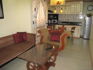 uma sala de estar com um sofá e uma mesa em Makati Suites at Travelers Inn em Manila