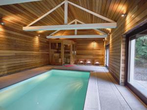 an indoor swimming pool in a wooden house at Luxurious Mansion in Stoumont with Indoor Pool in Stoumont
