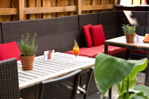 a patio with a bench and a table with a drink on it at Kretschmanns Hotel in Sehnde