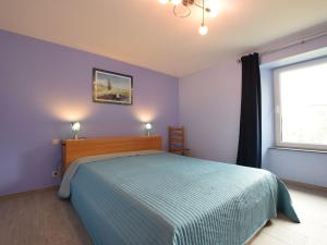 um quarto com uma cama com paredes azuis e uma janela em Pretty cottage with billart and 2 bathrooms em Marfontaine