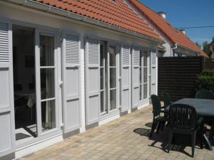 a patio with a table and chairs next to a building at Floris'Home in De Haan