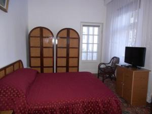 a bedroom with a red bed and a tv at Hotel Tantzi in Sinaia