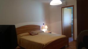 a bedroom with a bed and a lamp and a door at Mary home in SantʼAlessio Siculo