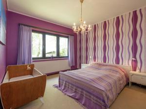 a bedroom with purple walls and a bed and a chandelier at Holiday Home in Waimes with Private Garden in Waimes