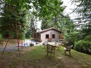 une petite maison avec une aire de jeux dans la cour dans l'établissement Chalet in a green and peaceful environment, à Houffalize