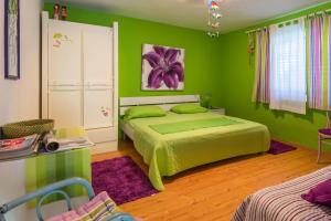 ein Schlafzimmer mit grünen Wänden und ein Bett in einem Zimmer in der Unterkunft Holiday Home Jovis in Drvenik