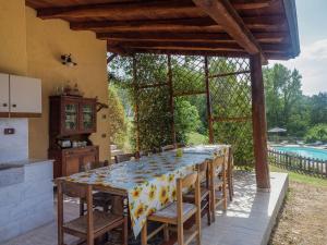 eine Küche und ein Esszimmer mit einem Tisch und einem Pool in der Unterkunft Belvilla by OYO Agriturismo Valle Fiorita in Aulla