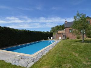 a swimming pool in a yard next to a house at Apartment with pool and sauna in Felenne
