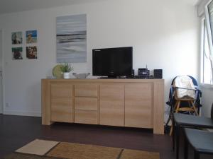 - une télévision sur un meuble en bois dans le salon dans l'établissement Au calme, avec jardin et proches des sites touristiques, à Vannes