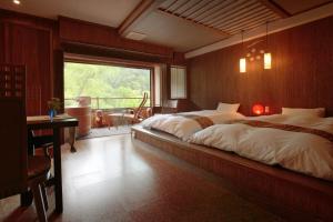 1 dormitorio con cama grande y ventana grande en Kansyokan, en Mogami