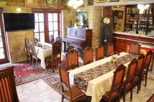 una sala da pranzo con tavolo, sedie e orologio di HOTELOWE Pokoje J.Bukowiecka a Tuszyn