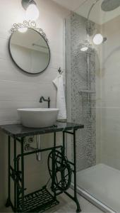 uma casa de banho com um lavatório e um chuveiro com um espelho. em Apartment The 29 em Zagreb