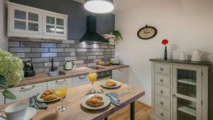 a kitchen with a table with two glasses of orange juice at Apartment The 29 in Zagreb