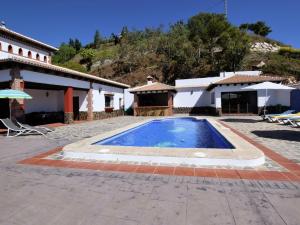 a villa with a swimming pool in front of a house at Belvilla by OYO Villa Alejandro in Sayalonga