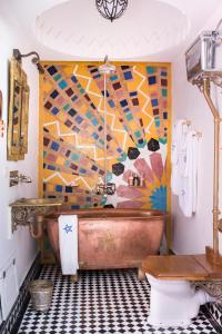a bathroom with a copper tub and a mosaic wall at Salut Maroc! in Essaouira
