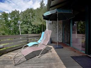 a pair of chairs and an umbrella on a porch at Modern Holiday Home in Stavelot with Terrace in Stavelot