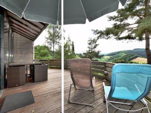 patio con 2 sedie e ombrellone su una terrazza di Modern Holiday Home in Stavelot with Terrace a Stavelot