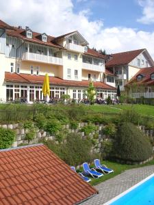 duas cadeiras e uma piscina em frente a um hotel em Komforthotel Ahornhof em Lindberg