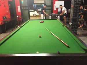 a pool table with two cuesticks and a ball on it at Vangvieng Rock Backpacker Rooftop Hostel in Vang Vieng