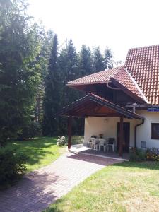 a patio with a table and chairs on a house at Apartmani U Borovoj Šumi in Zlatibor