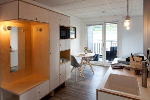 eine Küche mit weißen Schränken und einem Esstisch in der Unterkunft Boardinghouse Morbach in Morbach