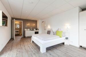 1 dormitorio con 1 cama blanca y cocina en Boardinghouse Morbach, en Morbach