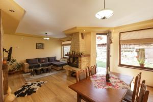a living room with a table and a fireplace at Rupchini Houses in Bansko