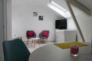 a living room with two chairs and a tv at Gîte LE JARDINIER in Épinal