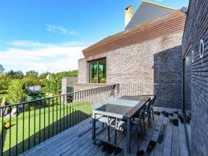 une terrasse en bois avec une table et des chaises. dans l'établissement Modern holiday home near Bruges and the North Sea, à Dudzele