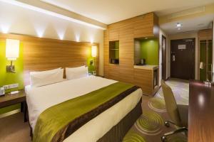 een hotelkamer met een groot bed en een bureau bij Holiday Inn - Kyiv, an IHG Hotel in Kiev