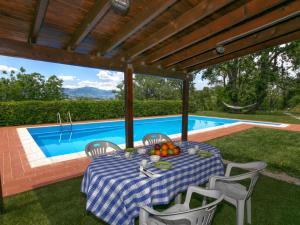 a table and chairs on a patio next to a swimming pool at Belvilla by OYO Villa Insieme in San Valentino in Abruzzo Citeriore