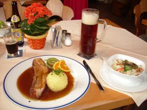a table with a plate of food and a glass of beer at Hotel Ahornhof, privates 27 qm großes Doppelzimmer mit Balkon in Südlage in Lindberg