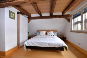una camera da letto con un grande letto e soffitti in legno di Les colombages d'a cote a Stetten