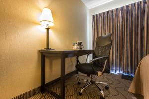 a room with a chair a lamp and a desk at Comfort Inn Airport in North Bay