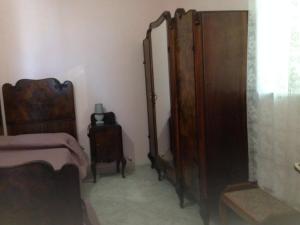 ein Schlafzimmer mit einem Bett und einem Holzschrank in der Unterkunft Casa Vacanze Silvia in Pizzo