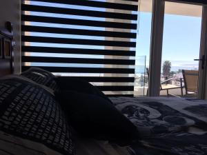 1 dormitorio con 1 cama y vistas a una ventana en Departamento en avenida del mar, en Coquimbo